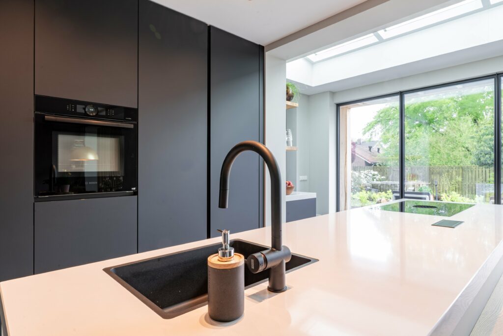 Tijdloze keuken van Mennen Keukens + Interieurs met Kookeiland en Fenix front in zwart kleur