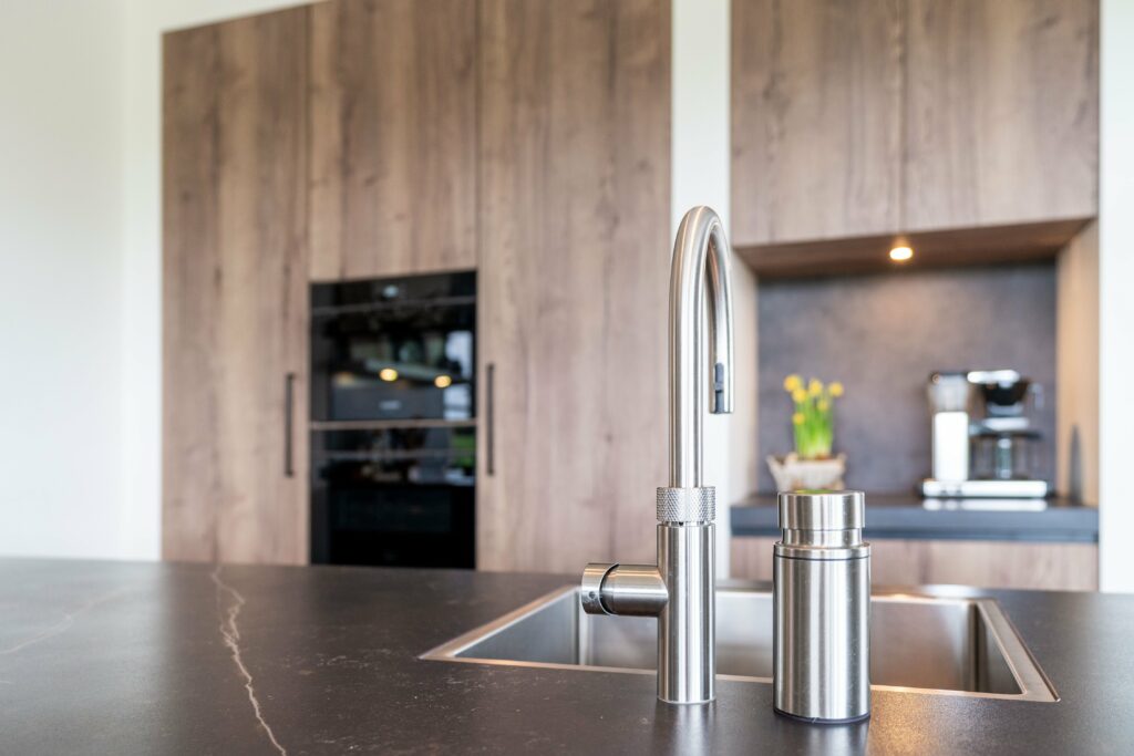 Moderne keuken van Mennen Keukens + Interieurs met Mereno Monza front in bruin en grijs kleur en kraan