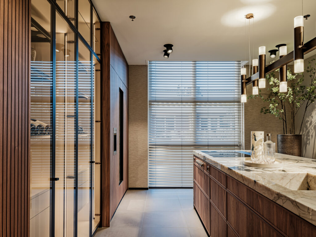 Luxe showroomkeuken van Tieleman Keukens met glaskasten, Mereno Seregno Altare front in notenfineer kleur en ledverlichting