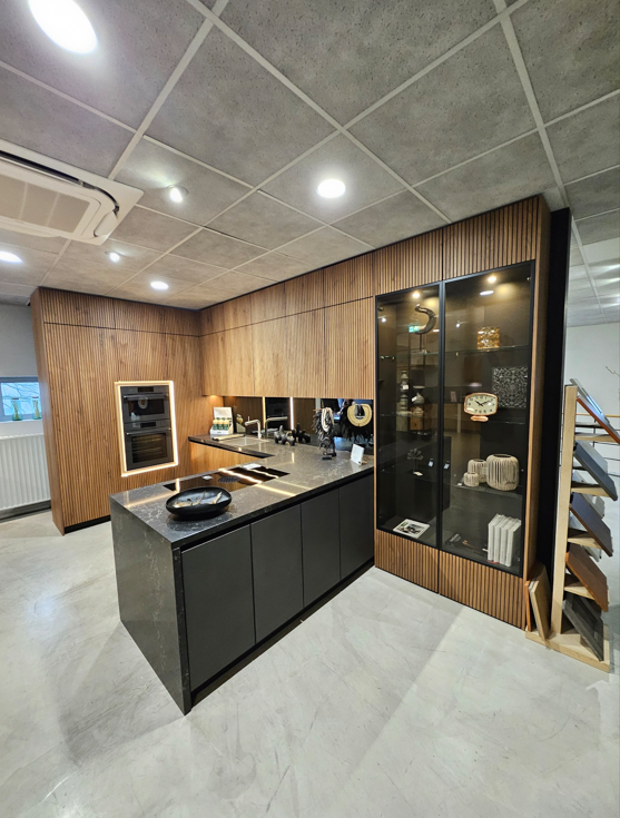 Showroomkeuken Tinnemans met Mereno Seregno front notenfineer, glaskasten en eiland met Mereno Cortona front
