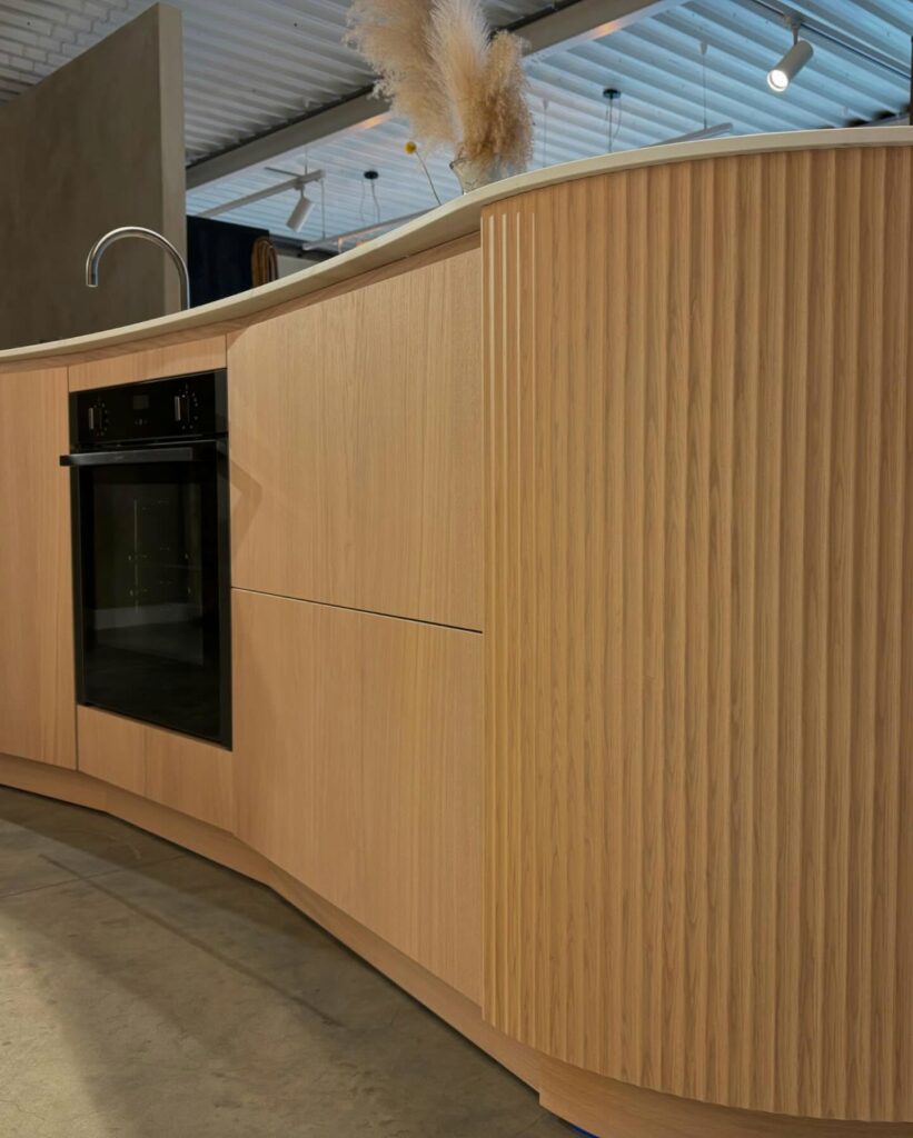 Japandi showroomkeuken van Puur keukens met organisch eiland, Mereno Milano front in ribbel en eiken kleur