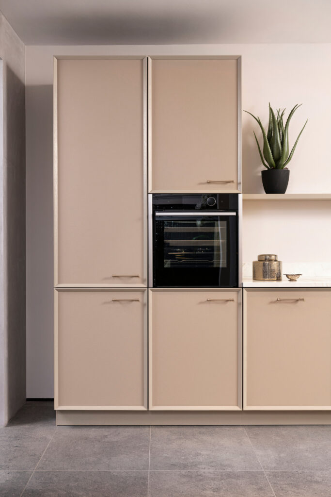 City chique showroomkeuken van Tieleman Keukens met Maison Sucre, Mereno Caprese front in beige kleur hoge kasten